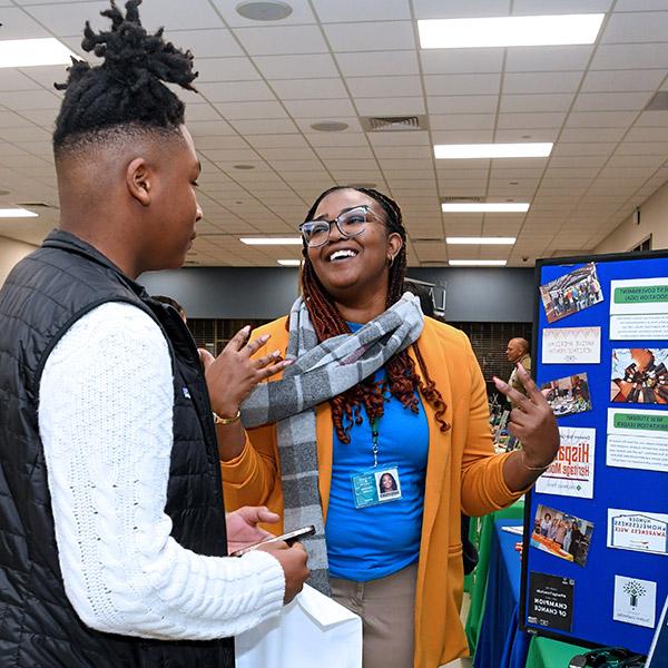 Student and staff member laughing while at new student orientation.